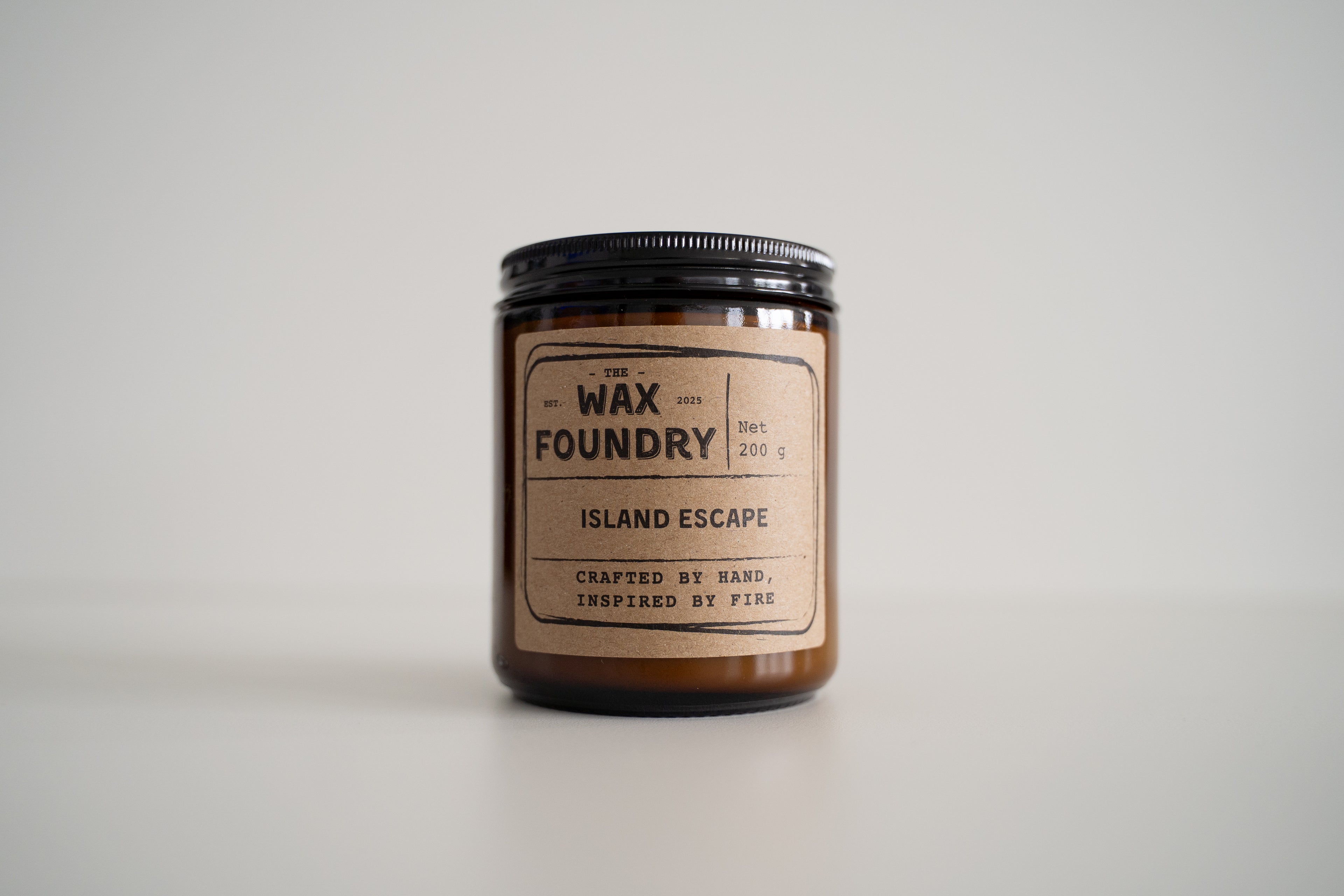 Candle from The Wax Foundry labeled 'Island Escape' on a light gray background