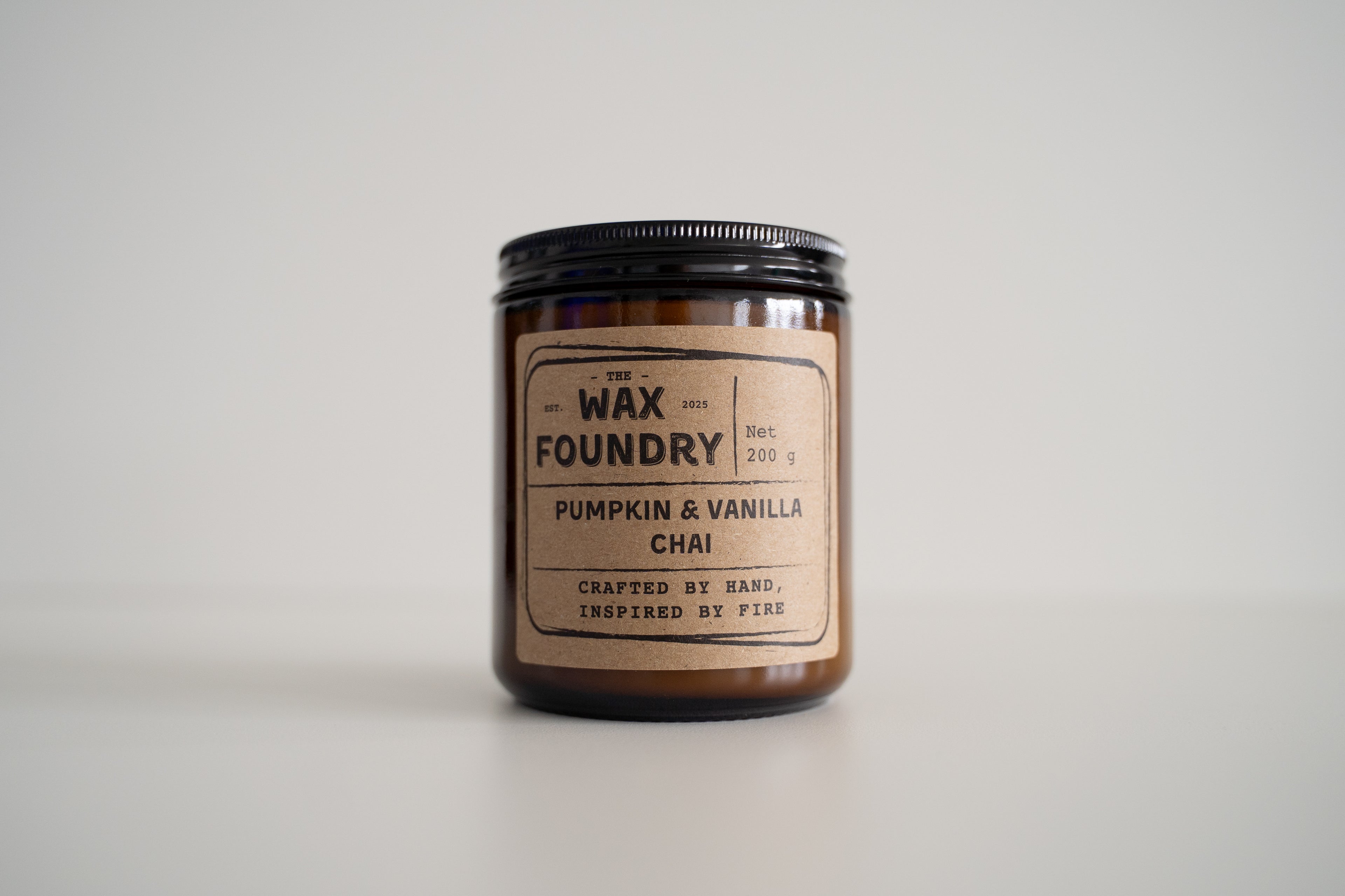Candle jar labeled 'The Wax Foundry' with 'Pumpkin & Vanilla Chai' on a light gray background