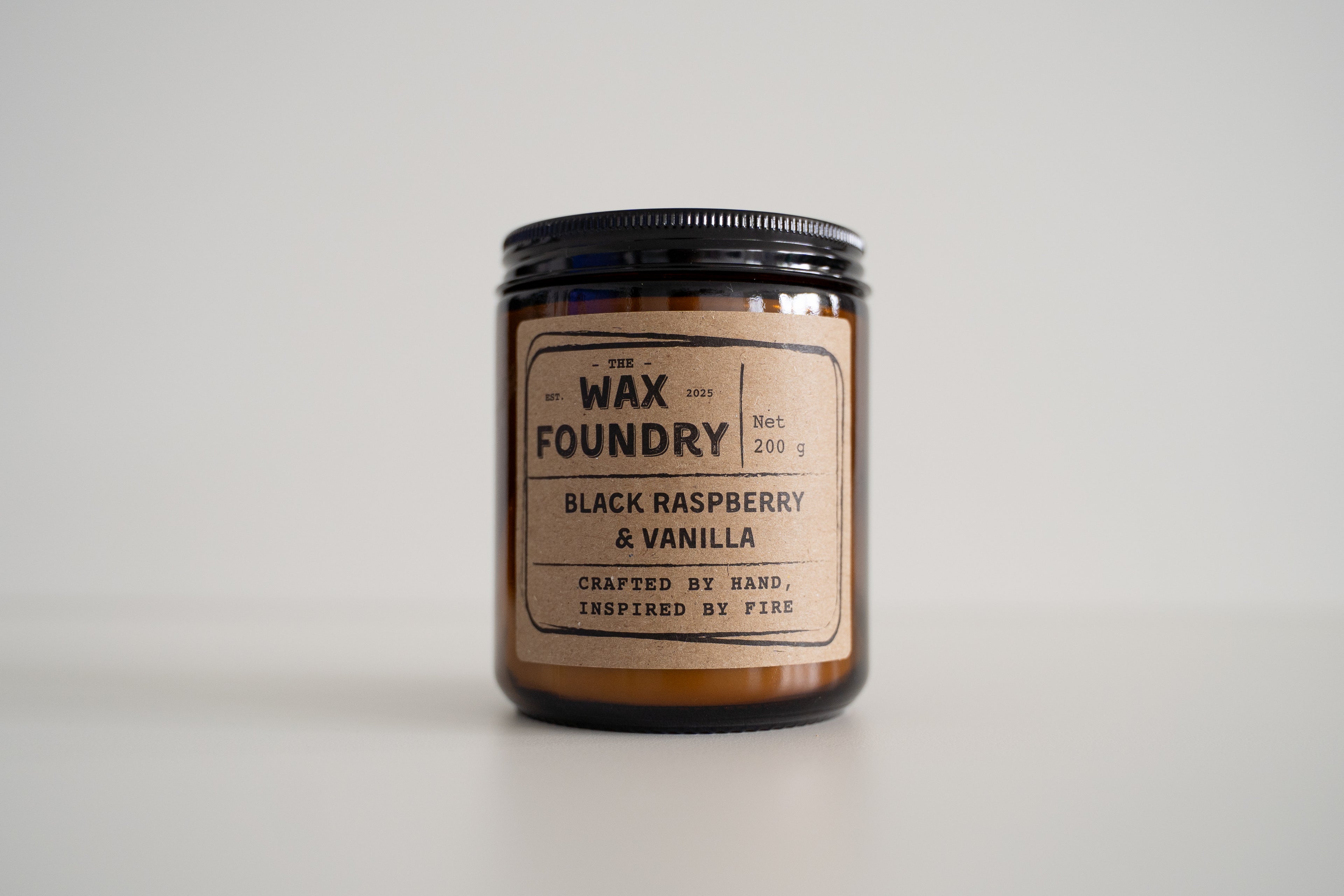 Candle jar with 'The Wax Foundry' label on a light gray background