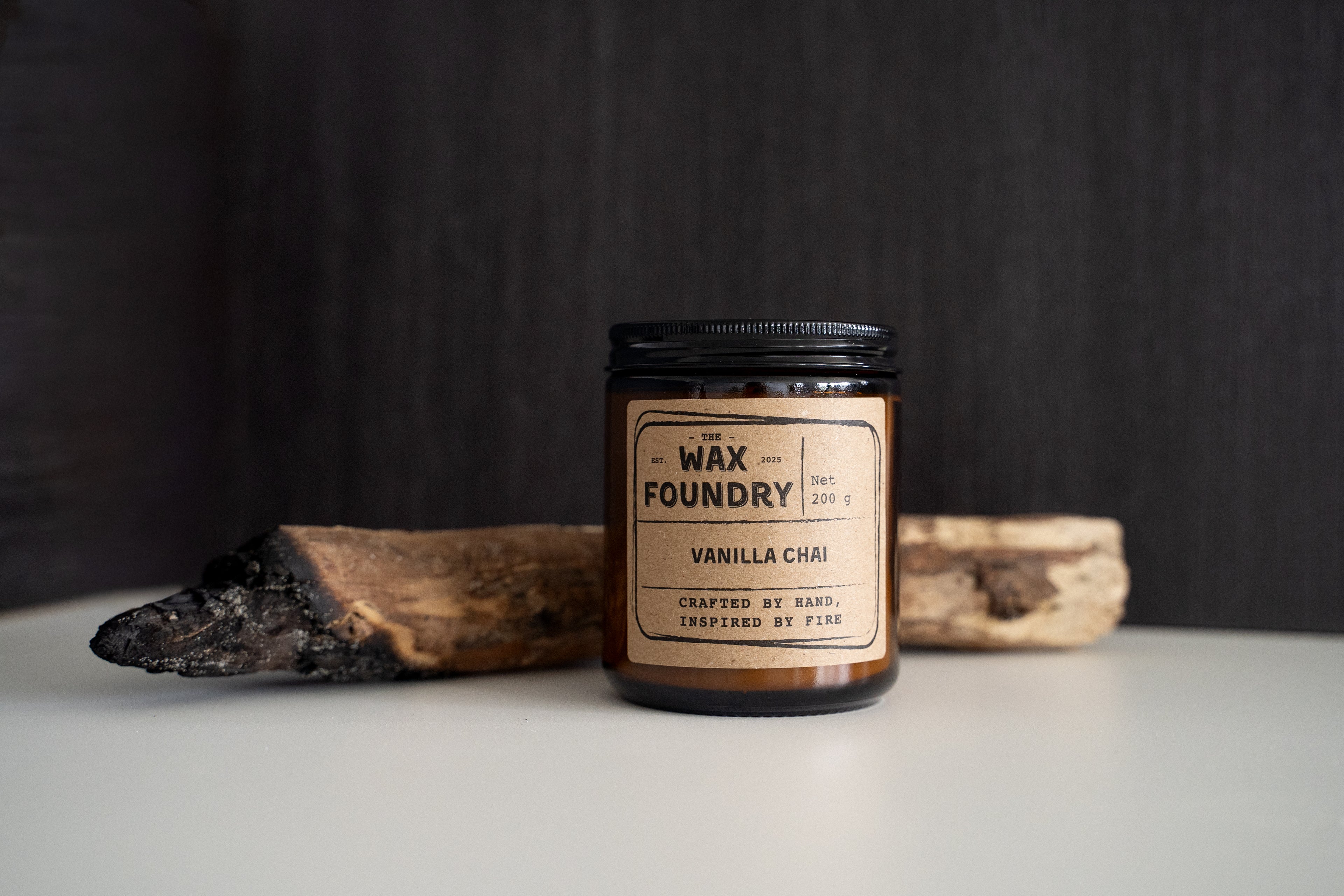 Candle jar labeled 'Wax Foundry' on a dark background