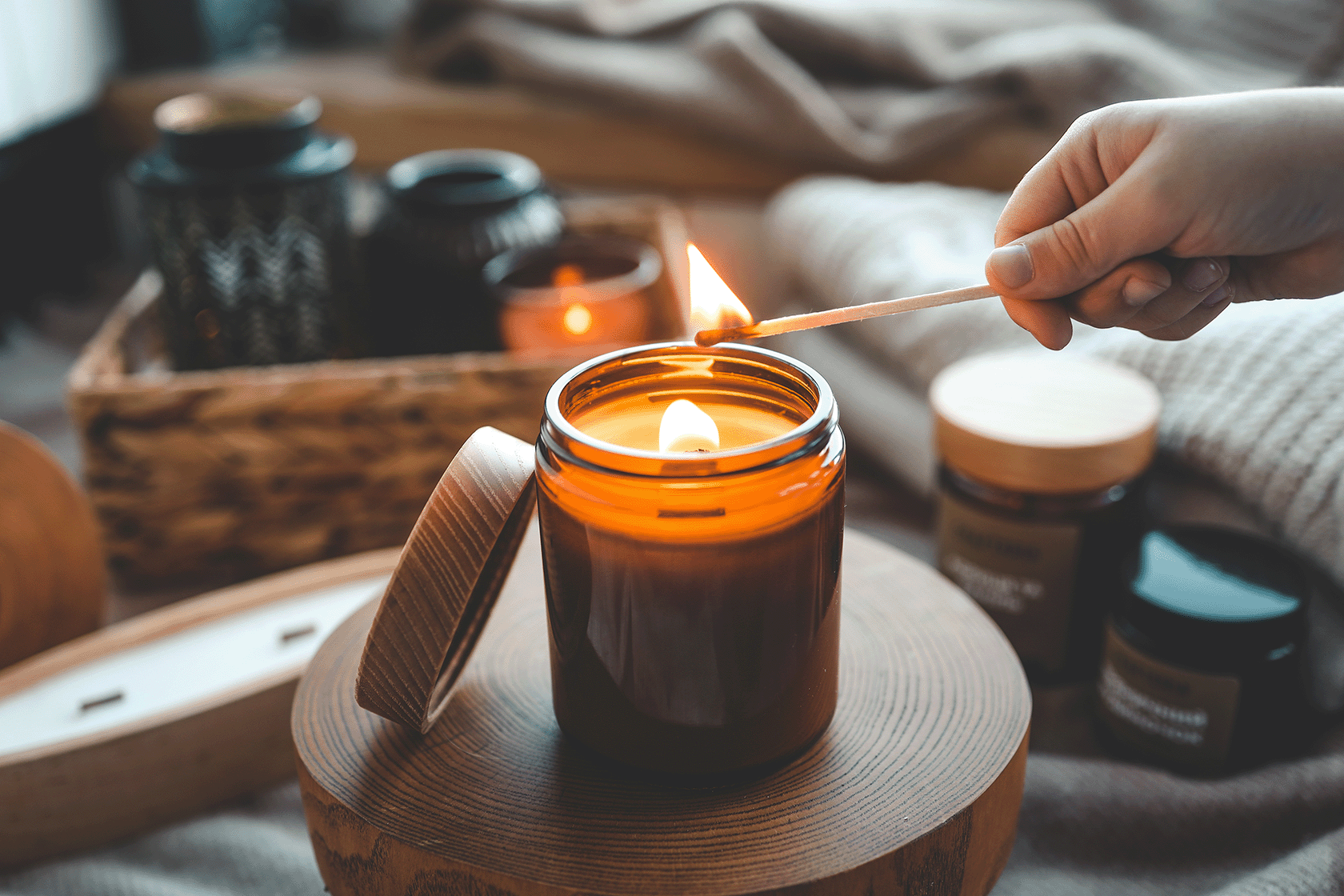 Candle being lit on a wooden surface with a cozy background